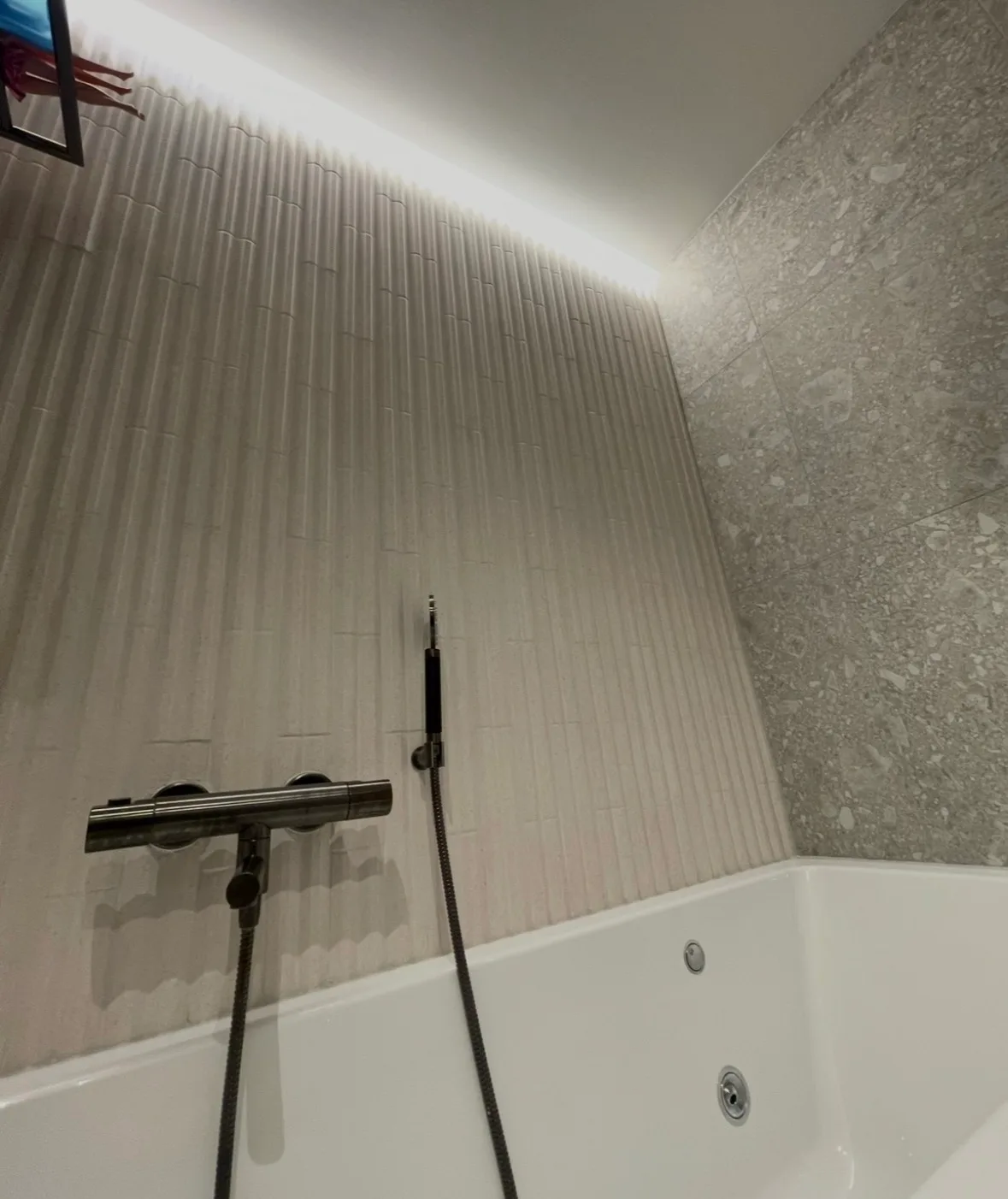 Modern bathroom with white tub and textured walls