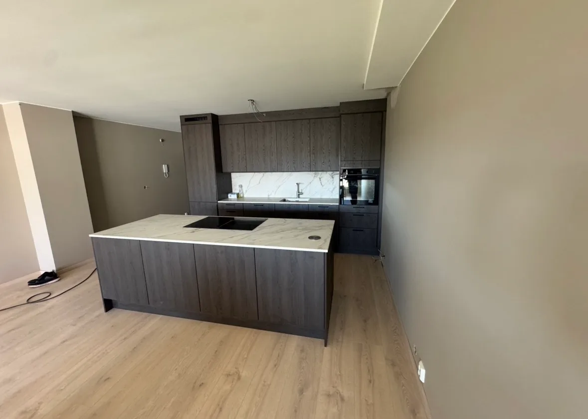 Modern kitchen with dark cabinets and marble island