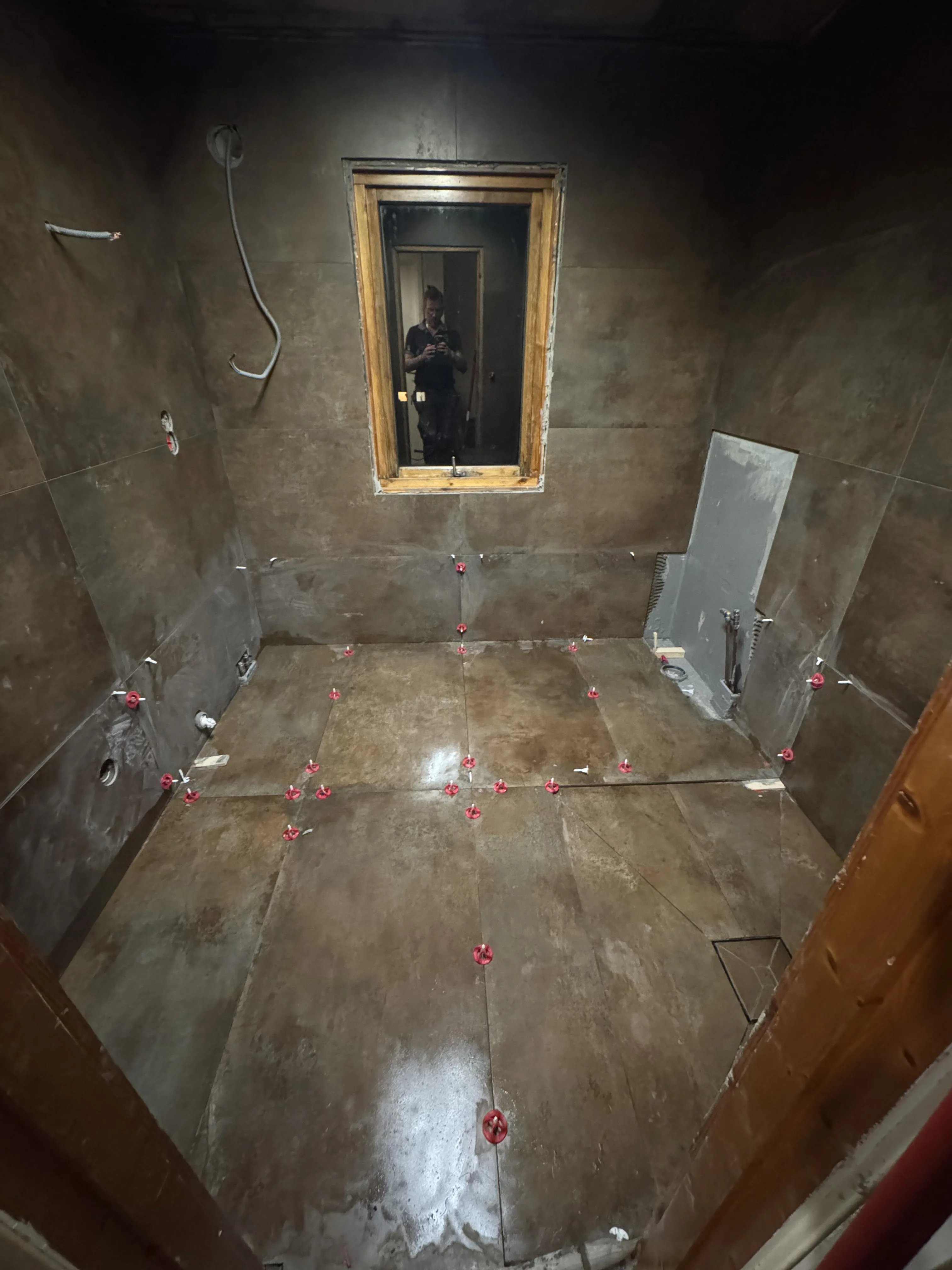 Bathroom renovation with tiled walls and mirror installation