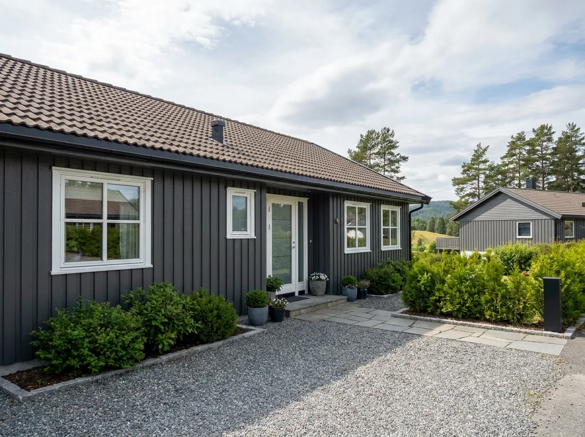Fint hus med moderne grå fasade og steinlagt inngangsparti
