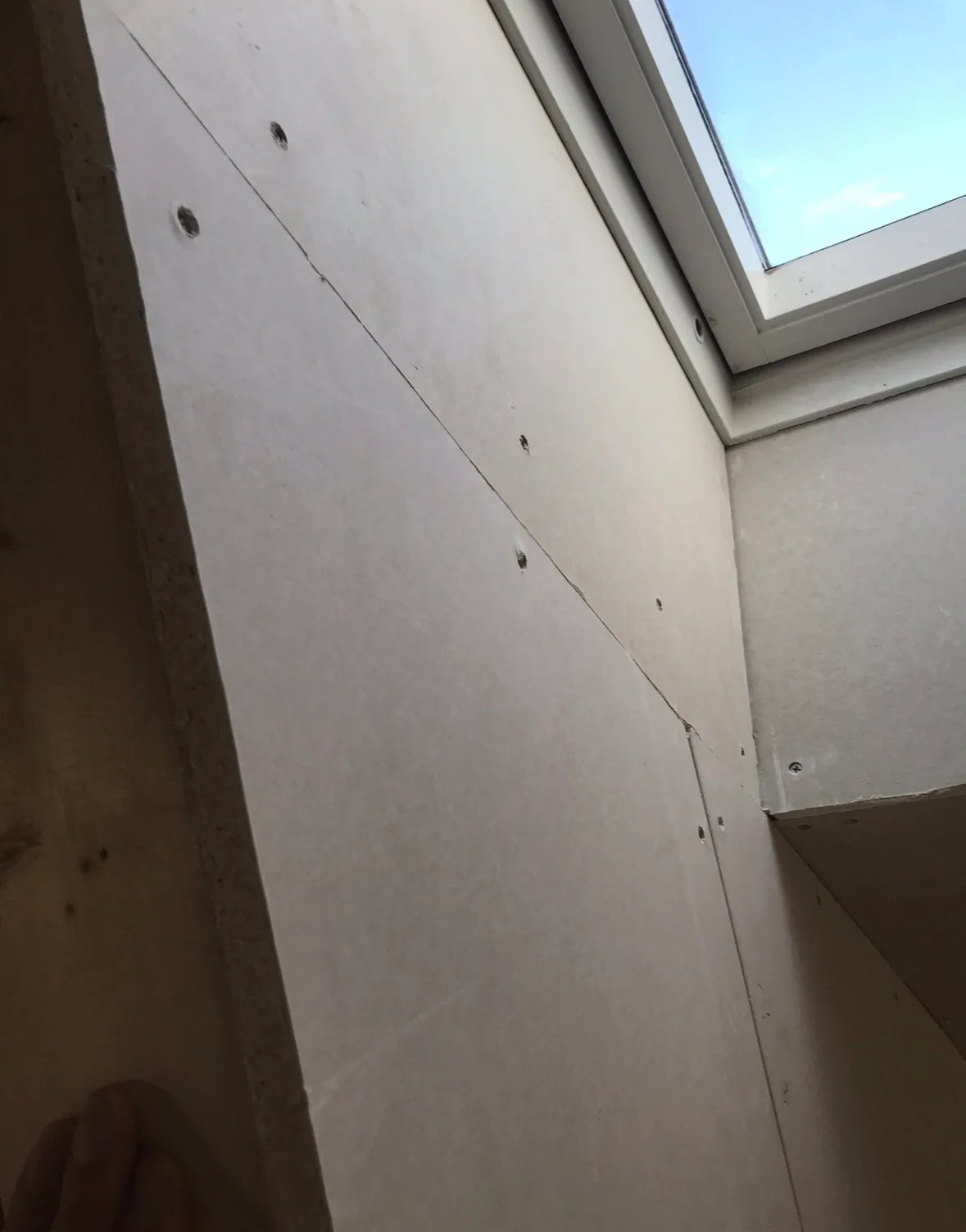 Gipsvegg som er installert ved vindu i byggeprosjekt