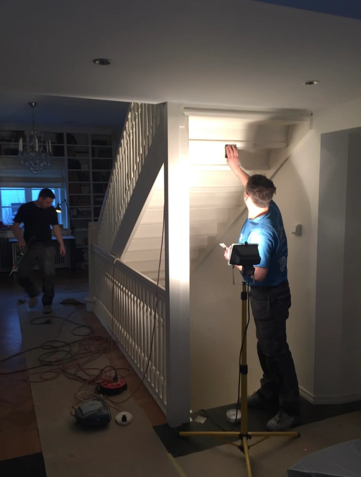 Arbeidere i ferd med å male trappen i et rom under oppussing