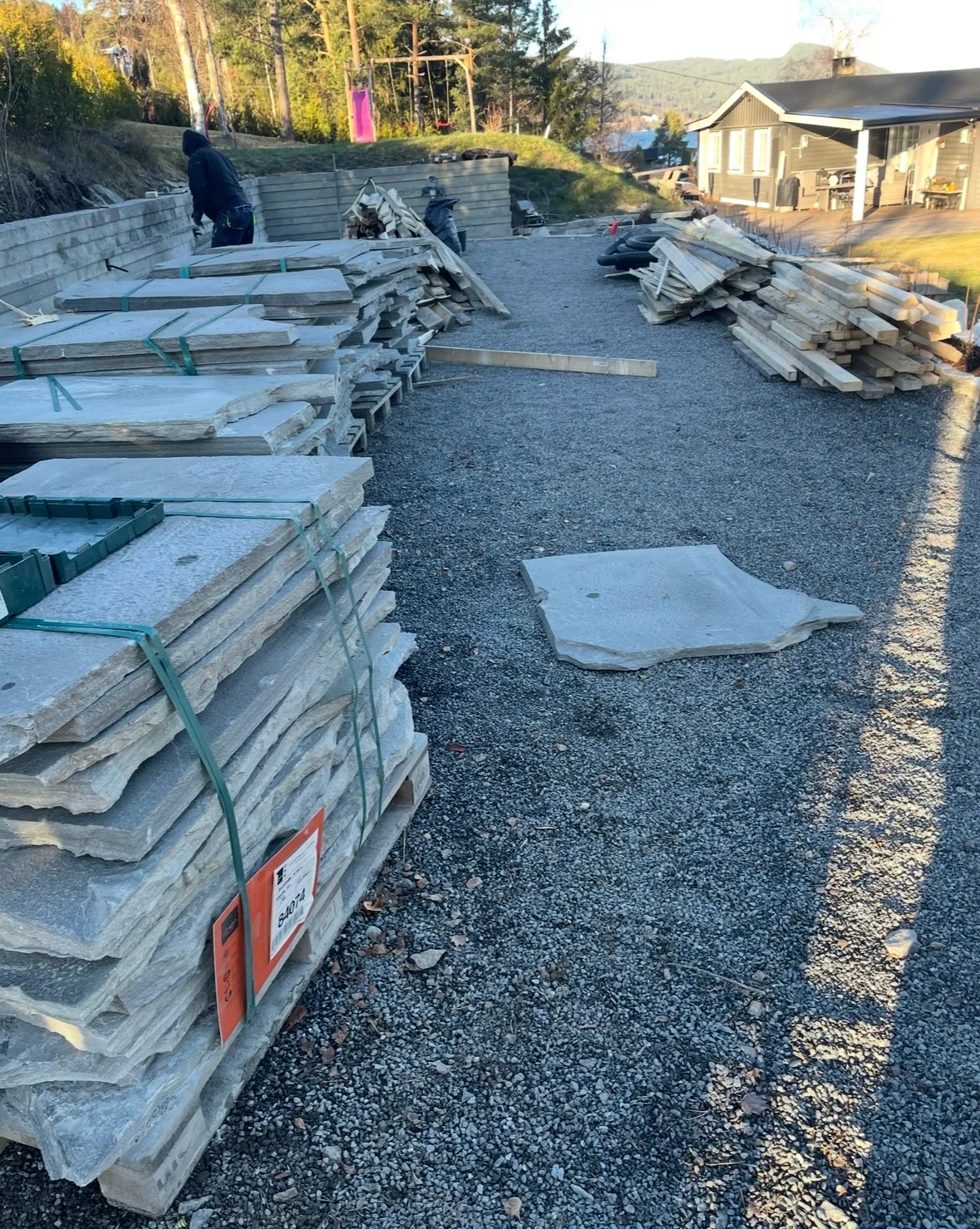 Stabel med steinplater og treverk i byggeområde for fasaderenovering